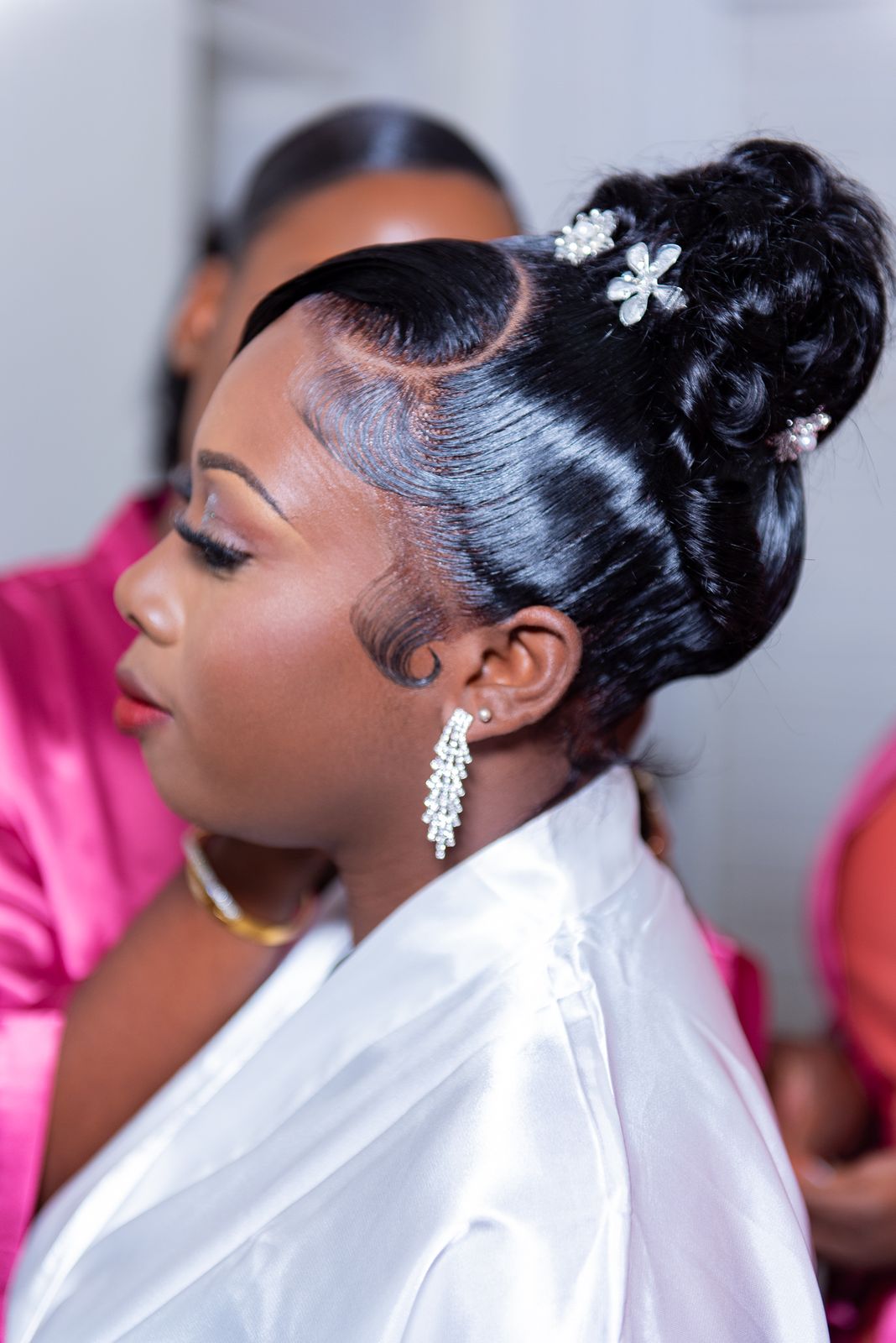 Close profile of the bride, hair pinned with a white flower and a drop earring