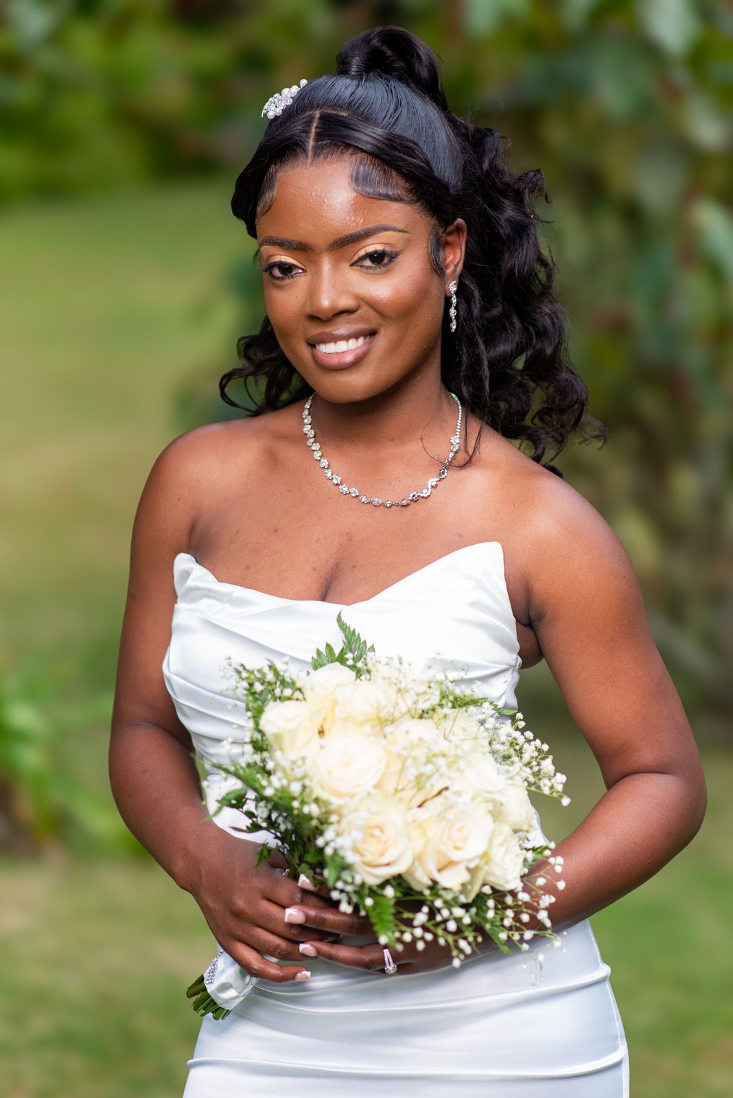 Portrait of the bride holding a bouquet of white roses and gypsophila