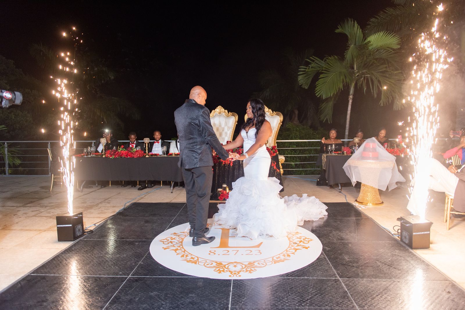 The couple cutting the cake between two fountains of sparks